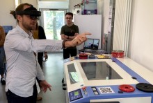 Utilisation de la réalité augmentée pour apprendre à utiliser la découpeuse laser Utilisateur avec un casque de réalité augmentée Hololens 2 devant les yeux qui pointe du doigt un objet virtuel