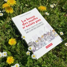 Livre "La bosse des maths n'existe pas" de Clémence Perronnet présenté sur un parterre de fleurs